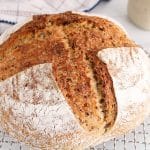 There is a homemade high protein sourdough quinoa bread on a cooling rack.
