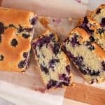 View on a few slices of a dairy-free sourdough blueberry bread on a cutting board.