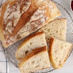 Same day sourdough bread half sliced on a cooling rack.