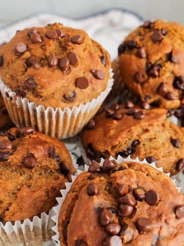 Pile of vegan pumpkin banana muffins on a plate.