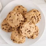 Pile of vegan oat flour cookie with chocolate chips on a white plate.