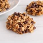 Vegan 4-ingredient banana oat cookie with chocolate chips on a counter.