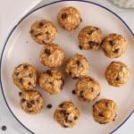 Healthy peanut butter bliss balls with chocolate chips on a white plate.