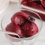 1-Ingredient cherry sorbet in a glass bowl with a spoon.