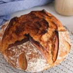A maple sourdough bread over a cooling rack.