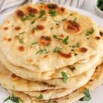 Pile of homemade vegan sourdough discard naan bread on a plate.