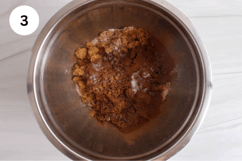 A mixing bowl with brown sugar, cinnamon and flour.