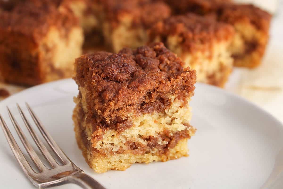 A square of coffee cake mad with sourdough discard place on a small plate.