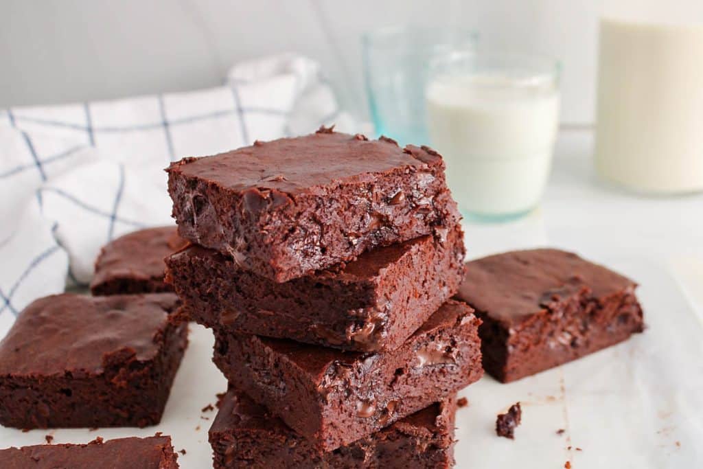 There are a few pieces of vegan sourdough discard brownies piled over each other.