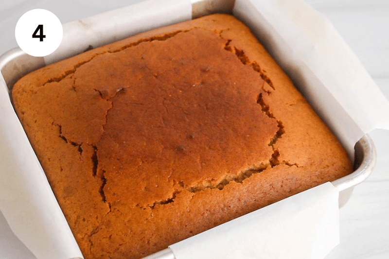 A square baking dish with a freshly baked vanilla cake.