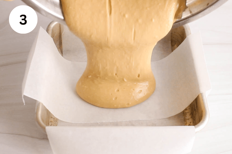 A cake batter pouring over a square baling dish.