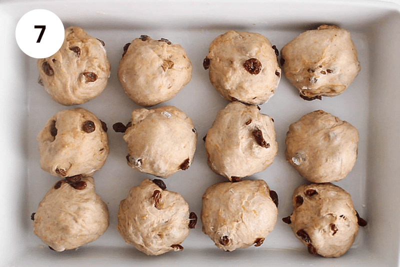 A baking dish with 12 balls of dough.