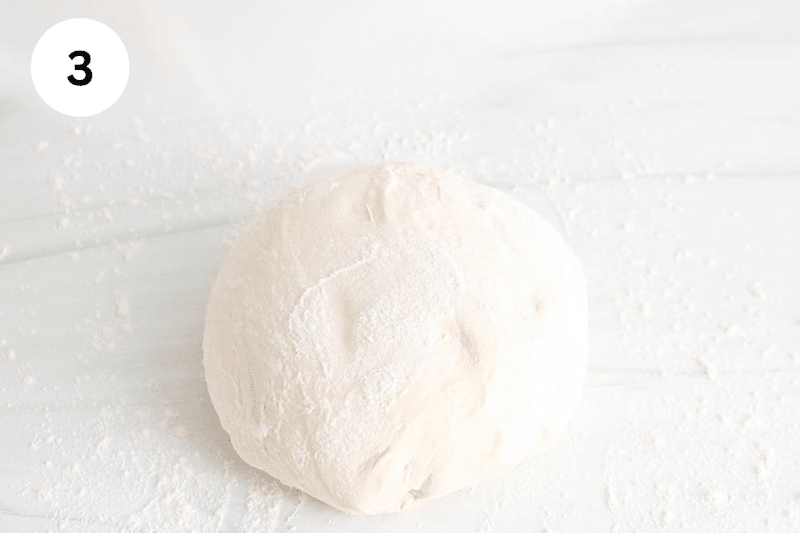 A ball of dough on a floured surface.