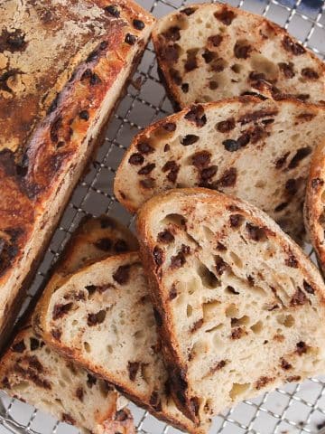 Sliced chocolate chips sourdough bread over a cooling rack.