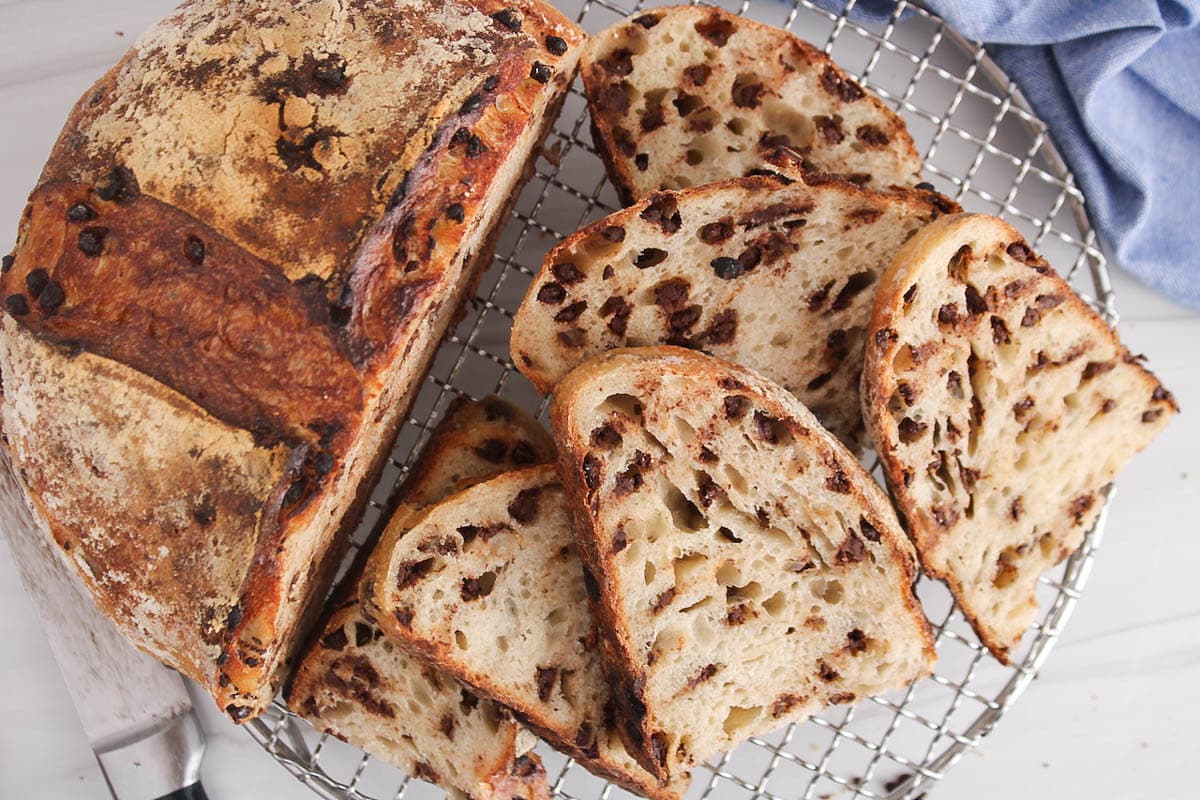 Sliced chocolate chips sourdough bread over a cooling rack.