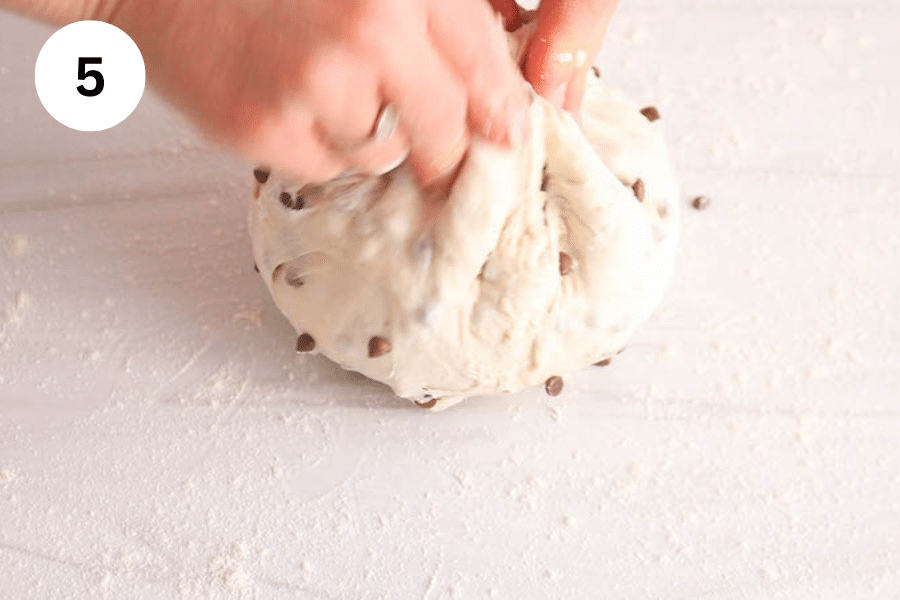 Hands shaping some dough into a ball.